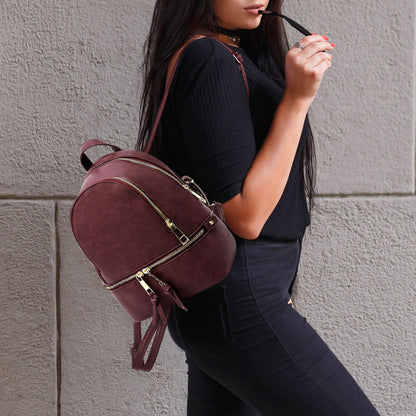Person wearing a Burgundy backpack against a gray wall